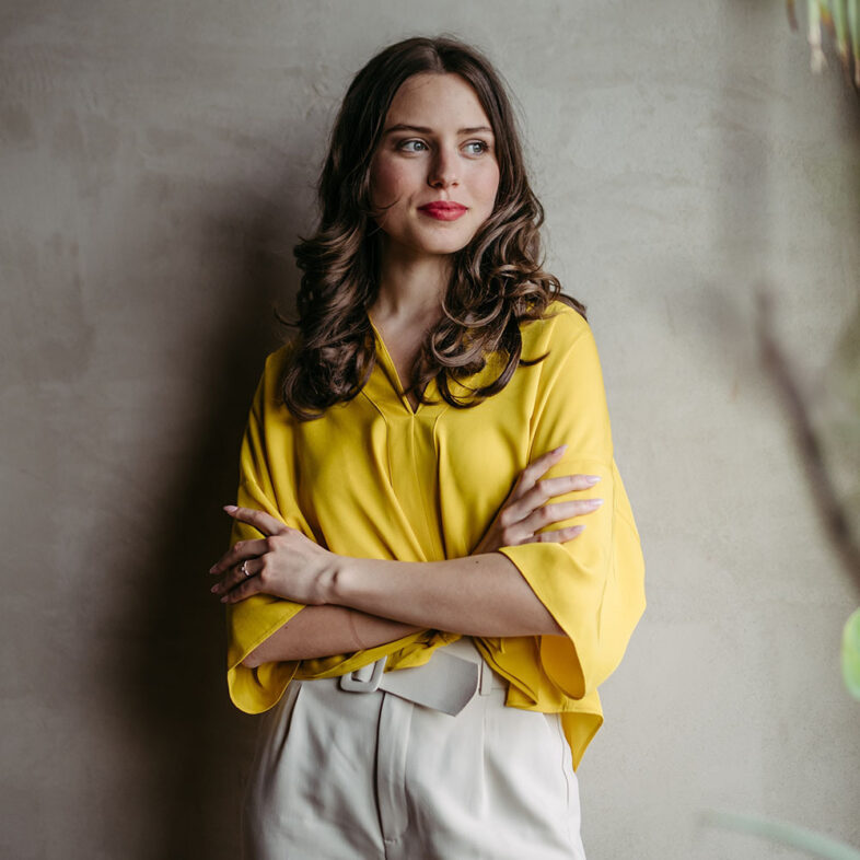 Business woman in yellow top and cream pants